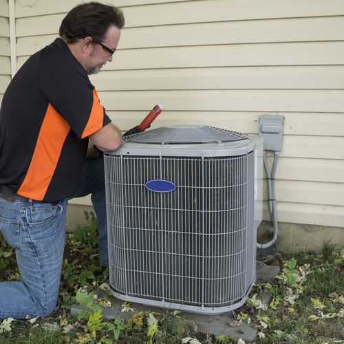 A Technician Repairs an AC.