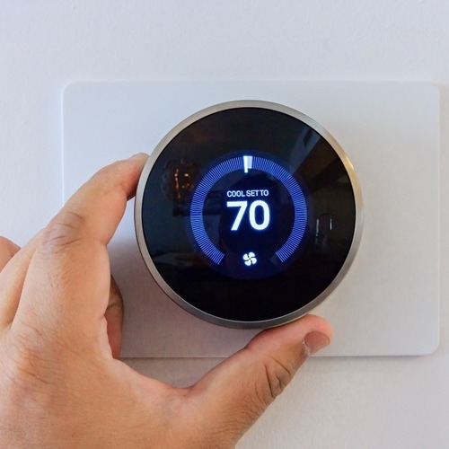 A Person Adjusts Thermostat