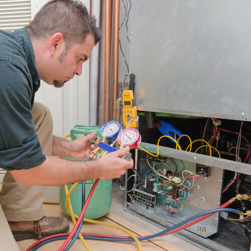 An HVAC Repair Technician Works on a Furnace.