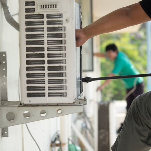 Technician Cleans Air Conditioner